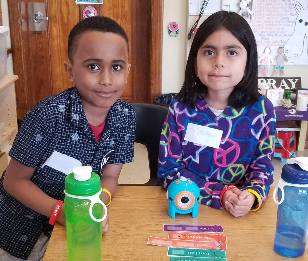 Two kids working together to build and analog program for Dot Robot