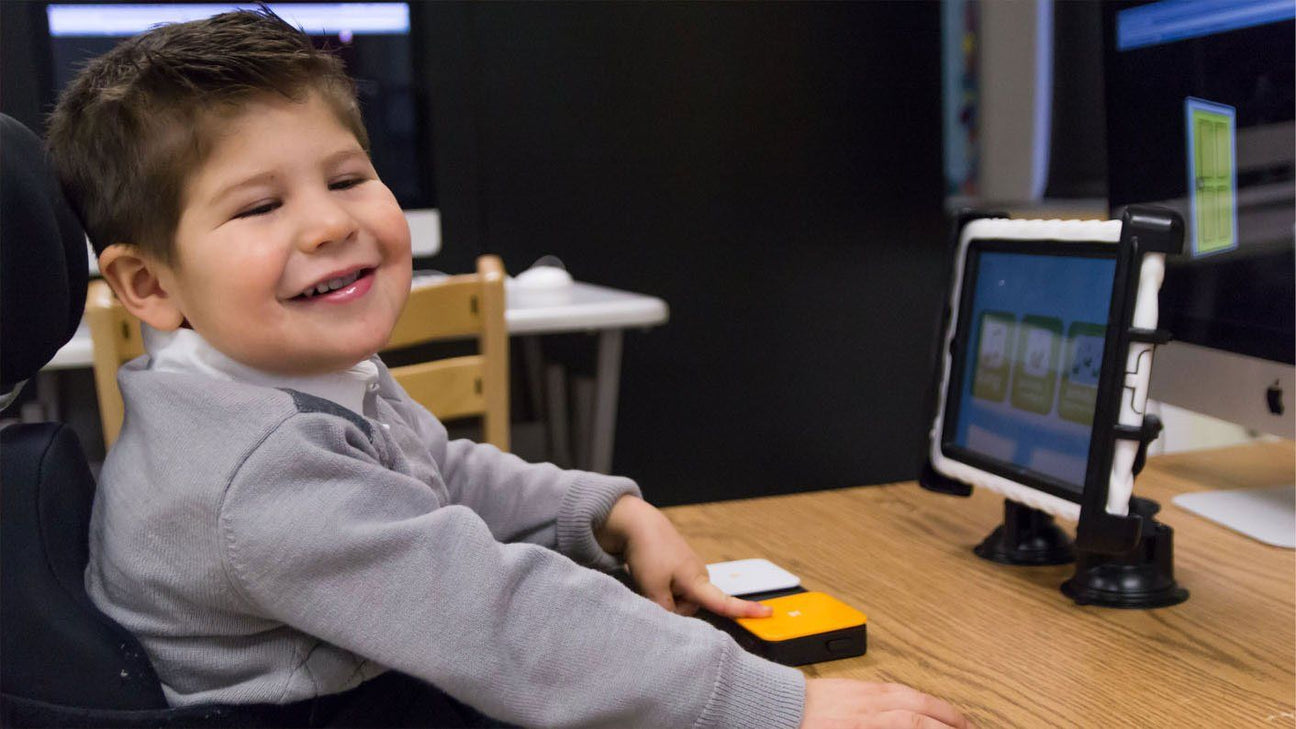 A student using a single switch to access a computer. 